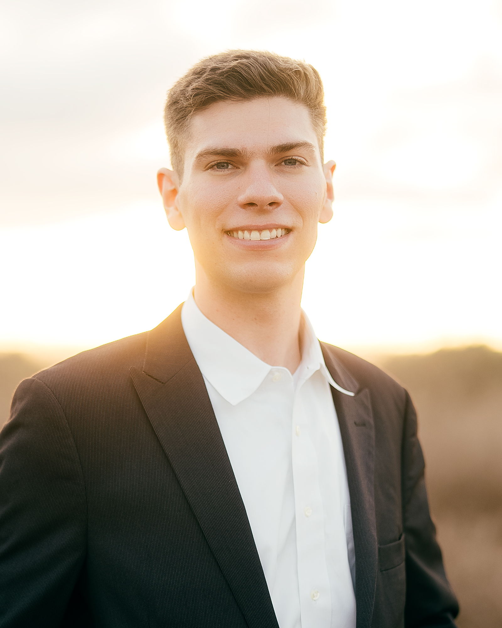 Portrait of Sam Marino outdoors in a dark suit.